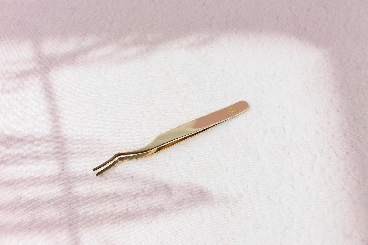 a gold colored toothbrush laying on a white surface