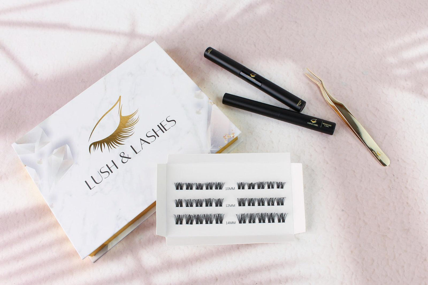 a box of eyelashes next to a pair of scissors